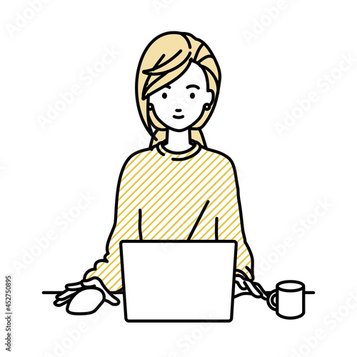 デスクで座ってPCを使っているリモートワークの女性