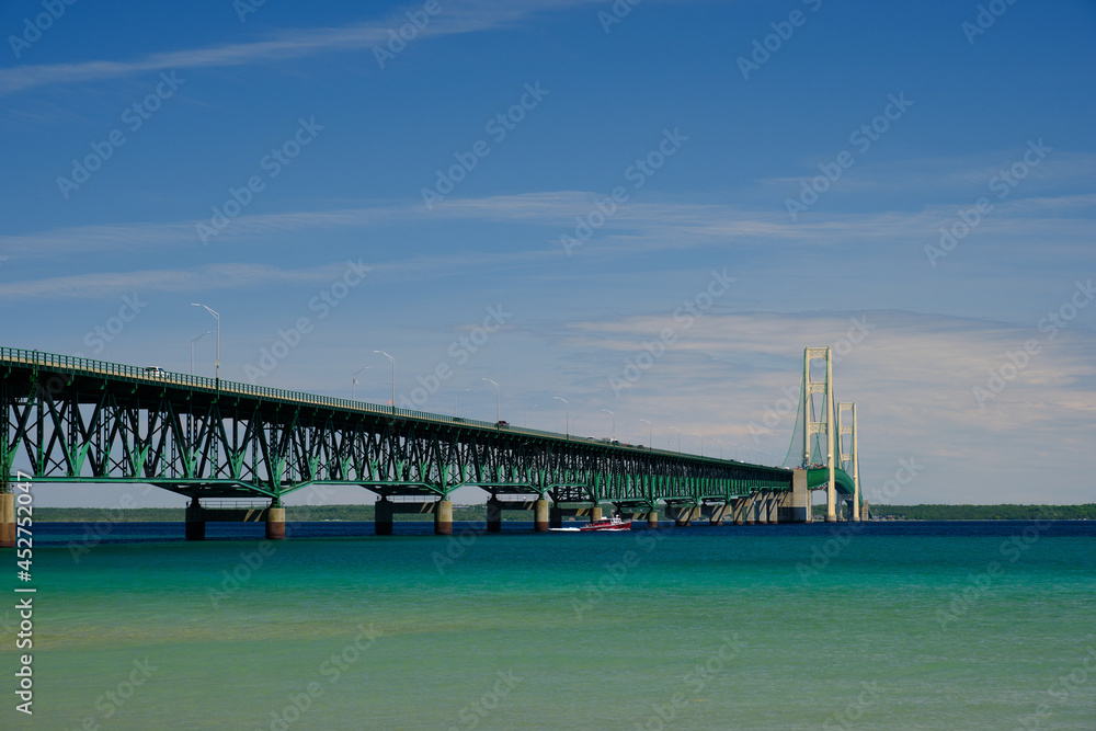 Obraz premium The colorful and clear waters of the straits of Mackinac and the Mackinac Bridge connecting the Upper and Lower Peninsula of Michigan