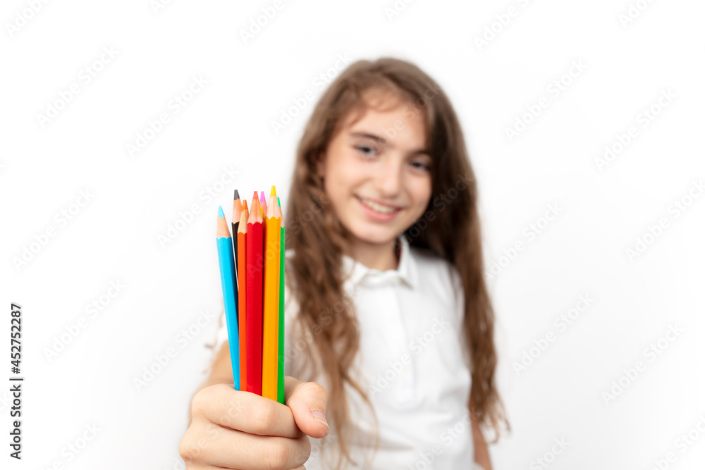 education, creativity, people, kids and school concept. Little student girl showing colorful crayons on white background. education, creativity, people, kids and school concept. Little student girl showing colorful crayons on white background.