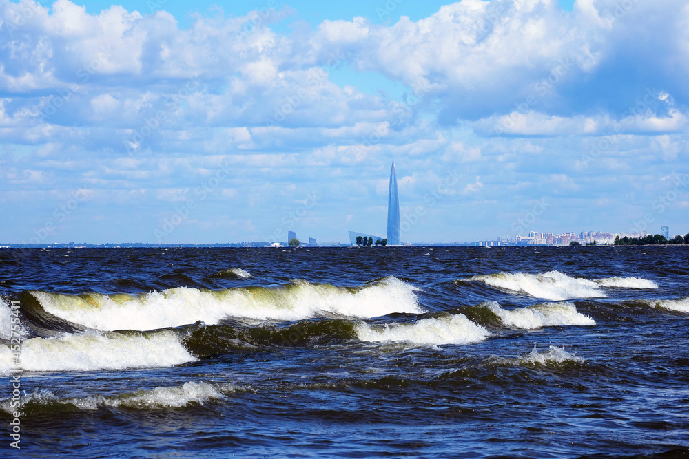 Waves on the Gulf of Finland Baltic Sea in sunny summer day. Lakhta center on background, Saint Petersburg, Russia