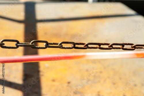 Metal chain on the background of sand and protective tape