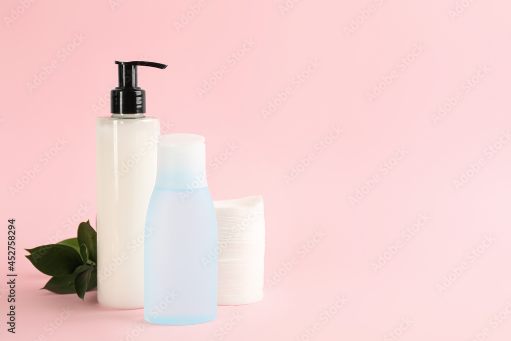 Cotton pads, leaves and makeup removal products on pink background. Space for text Cotton pads, leaves and makeup removal products on pink background. Space for text