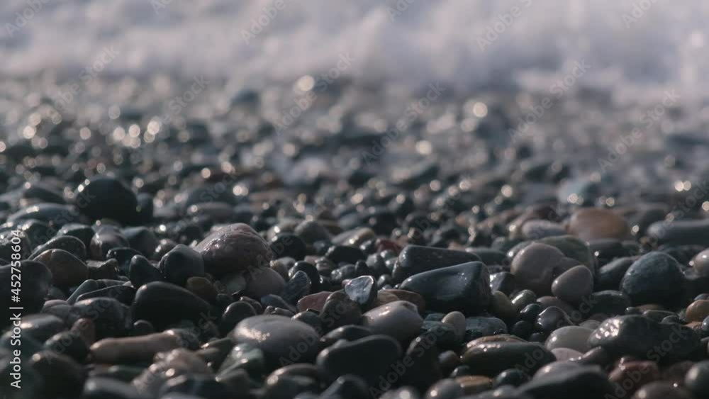 Pebbles by the sea. Sea waves, focus on the stone close-up. Pebbles by the sea. Sea waves, focus on the stone close-up.