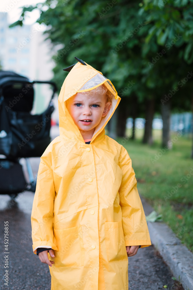 Portrait of a little boy in a yellow raincoat.