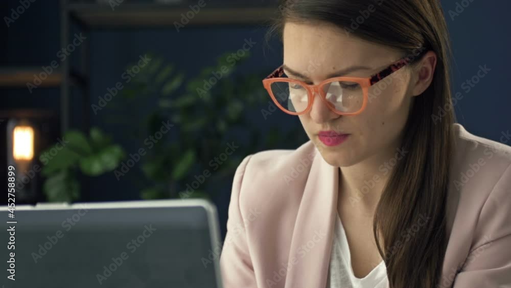 Portrait of a middle-aged woman working at a laptop. She is focused and thoughtful. Portrait of a middle-aged woman working at a laptop. She is focused and thoughtful.