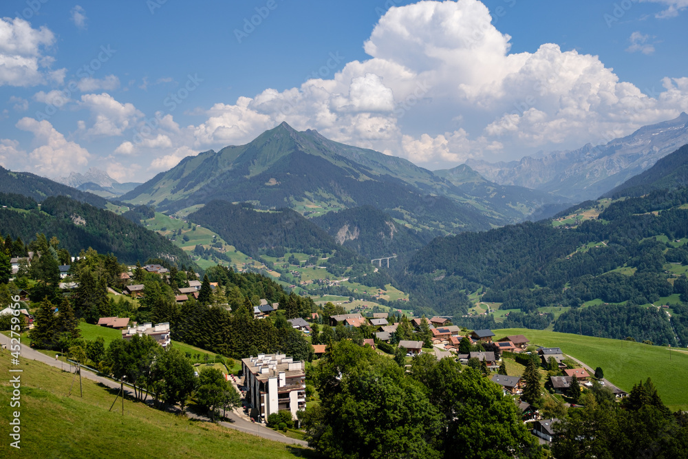 High agle panorama of alpine village Leysin with Pic Chaussy mountain in the background in summer under a blue sky with some white clouds