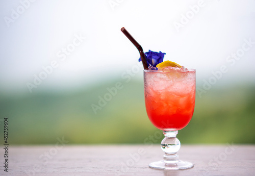 Italian red cold soda on wooden table in natural atmosphere against blurred background.. photo
