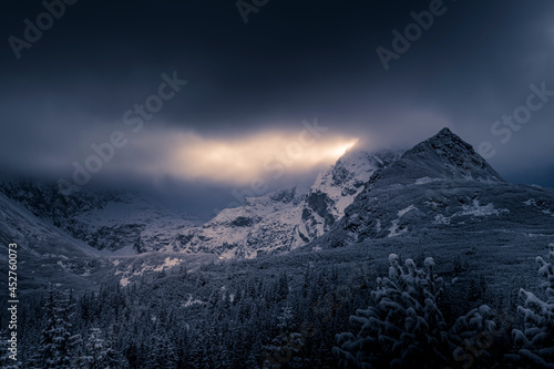 Fototapeta Naklejka Na Ścianę i Meble -  Sunlight behind Kościelec Peak, High Tatra Mountains, Poland. The view from Hala Gąsienicowa Valley. Selective focus on the rocks, blurred background.