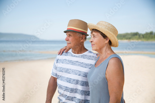 Portrait of senior couple embracing by the beach sea on a sunny day together