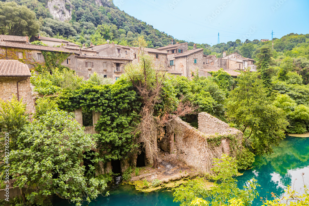 A glimpse of the small village of Stifone, on the Nera river. Umbria, Terni, Italy. The walls of stones and bricks. The bridge over the river with clear blue waters. A glimpse of the small village of Stifone, on the Nera river. Umbria, Terni, Italy. The walls of stones and bricks. The bridge over the river with clear blue waters.