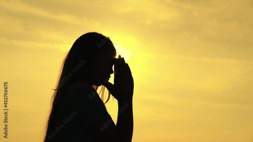 A Muslim girl prays in the glare of the sun in the sky, a little teenager believes in goodness, ask for forgiveness from heaven, educate a kid in religion, ask for good things in life, child dream of