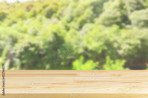 wood table top on blur tree and green foliage background