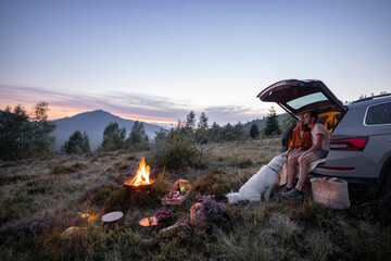 Couple by the fire at picnic in the mountains