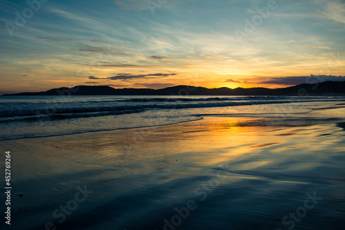 Nascer do sol na praia com nuvens  reflexo e ondas - Paisagem natural