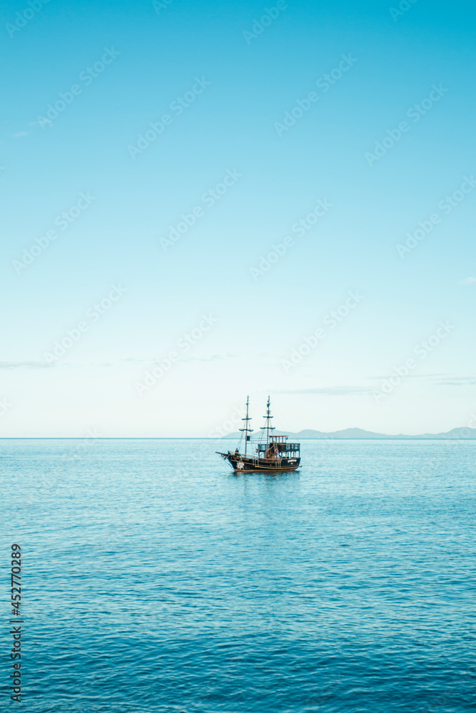 Mar calmo com barco pirata e céu azul - Paisagem natural Mar calmo com barco pirata e céu azul - Paisagem natural