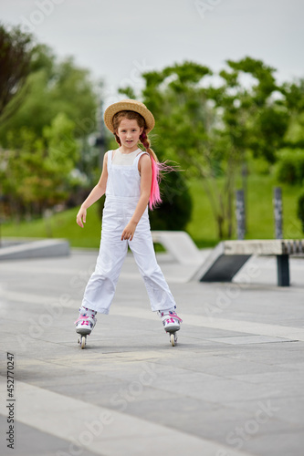 Cute little child girl on roller skates at park