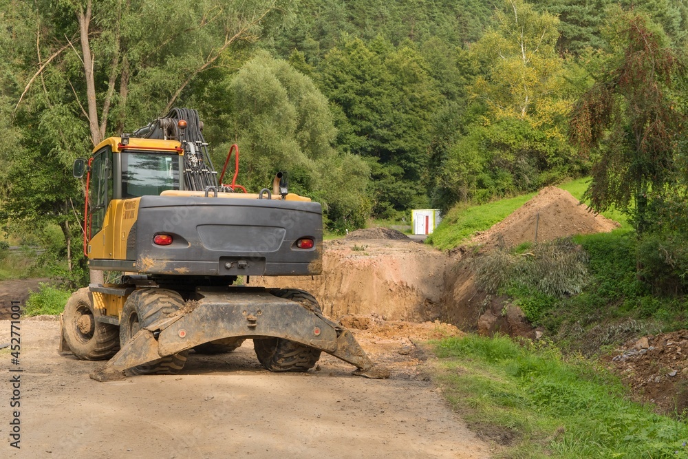 Repair of a road bridge in the Czech Republic near the village of Rikonin. Excavator on an empty construction site. Road repair.