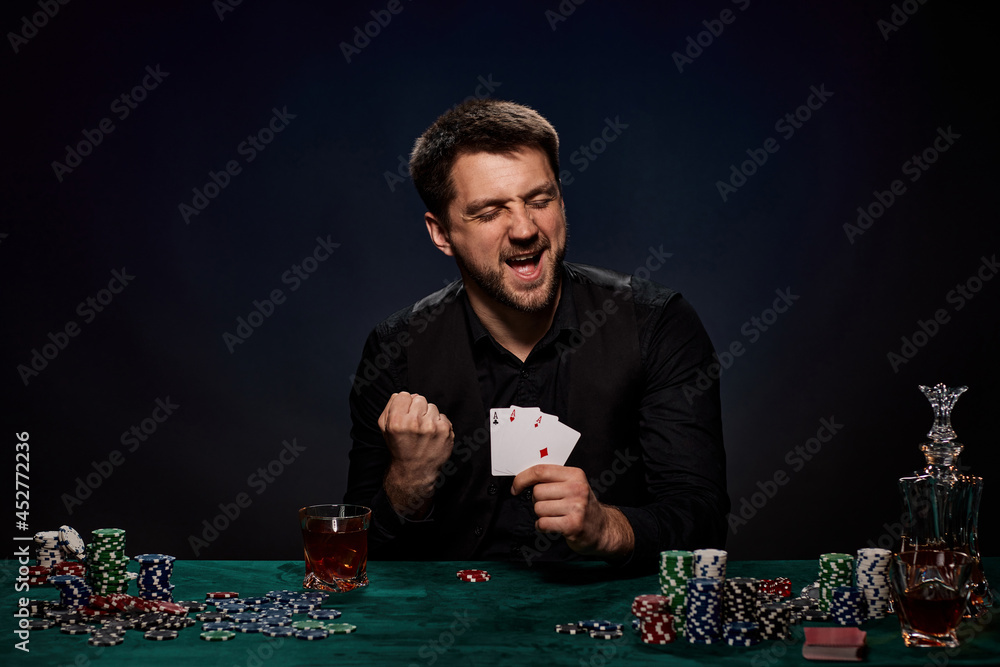 Bearded casino player man playing poker on green table Bearded casino player man playing poker on green table