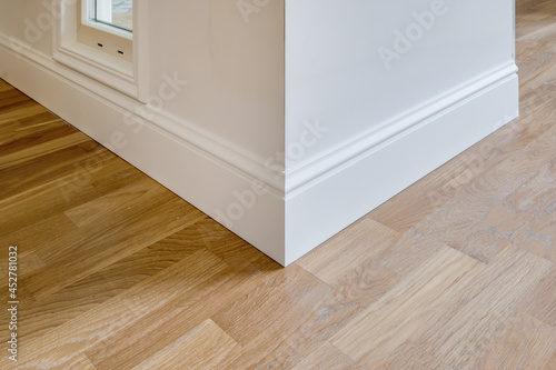Bild auf Leinwand Detail of corner flooring with intricate crown molding and plinth