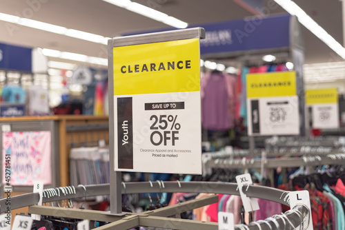 25 percent off clearance sign on a round clothing rack at fashion store in America