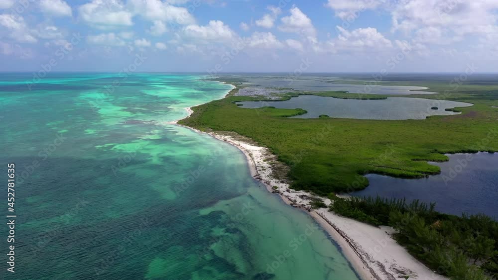 Aerial Beautiful Shot Of Sea Amidst Green Natural Landscape Against Cloudy Sky, Drone Flying Over Sea On Sunny Day - Cozumel, Mexico Aerial Beautiful Shot Of Sea Amidst Green Natural Landscape Against Cloudy Sky, Drone Flying Over Sea On Sunny Day - Cozumel, Mexico