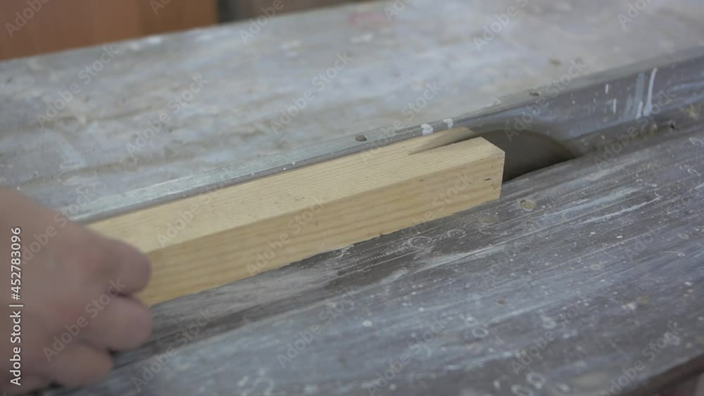 male hands sawing a wooden block on a special machine male hands sawing a wooden block on a special machine