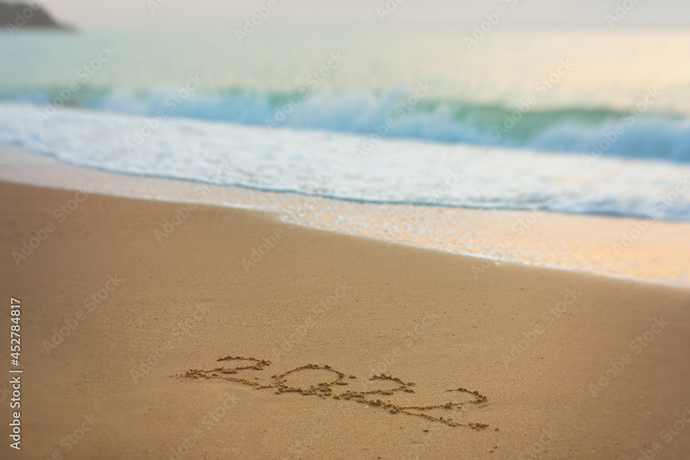 2022 Happy New Year inscription sand beach. The written text is written on yellow sand and is washed away by a wave. The concept of changing the year, the holiday. Mockup postcards copy space 2022 Happy New Year inscription sand beach. The written text is written on yellow sand and is washed away by a wave. The concept of changing the year, the holiday. Mockup postcards copy space