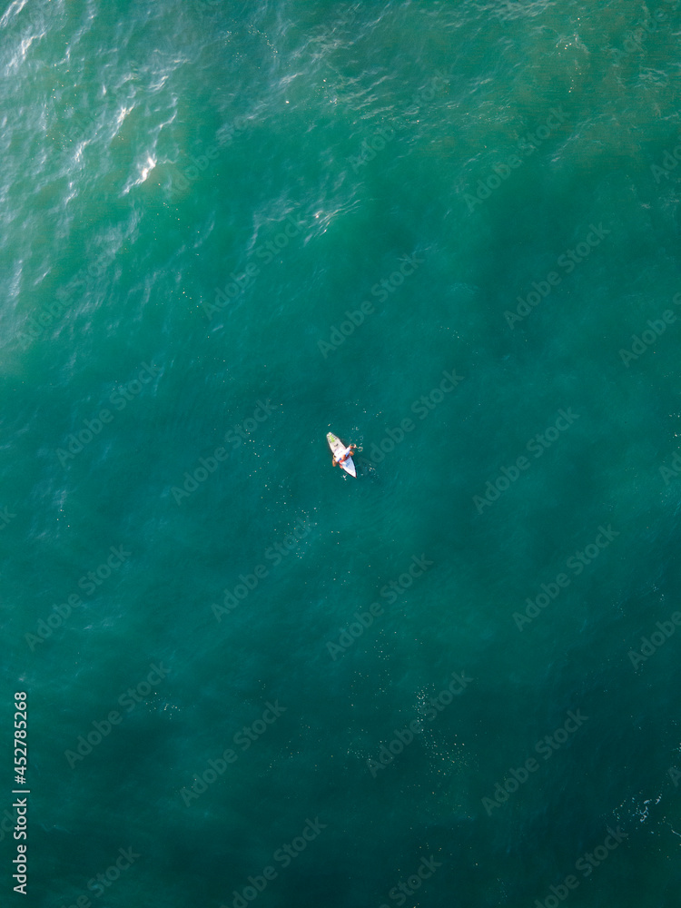 surfer in the middle of the sea top view