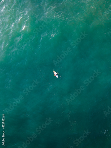 surfer in the middle of the sea top view