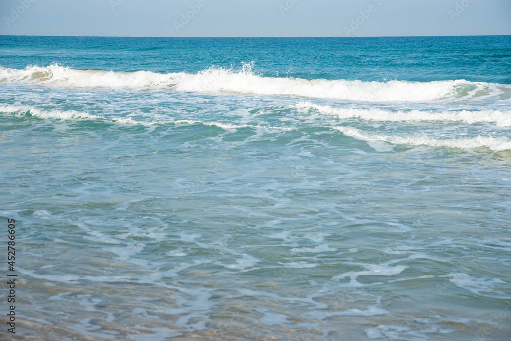 Sea or ocean tropical landscape view. Sea waves under the sun. Summer vacation and travel concept. Water wave surface. Sand beach. 