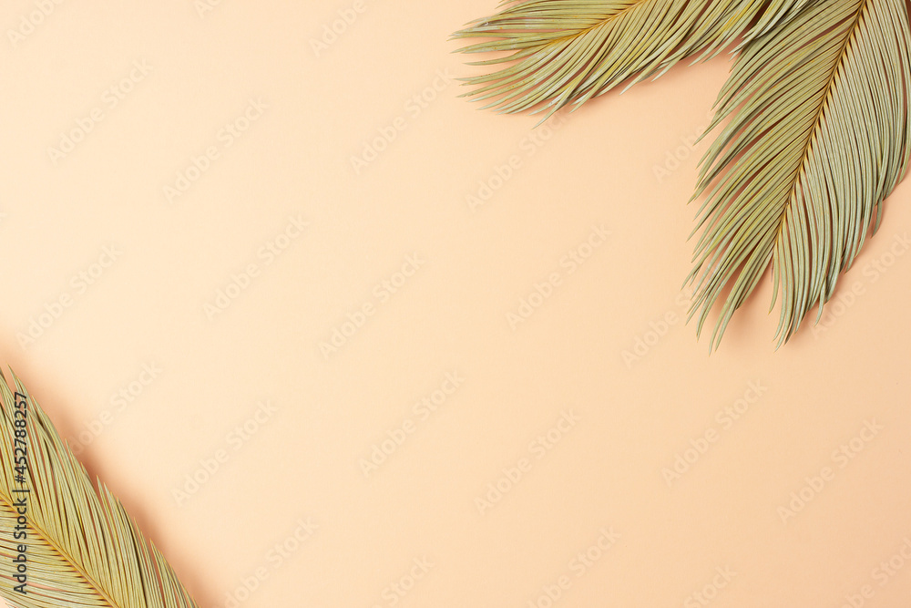 Tropical background with palm leaf on pastel beige. Flat lay, copy space