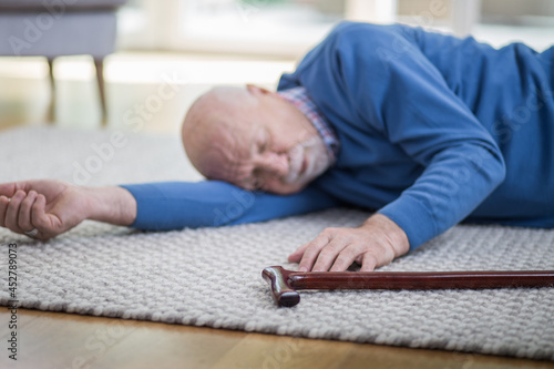 Quadro em tela Senior man in blue sweater lying on the floor of his apartment