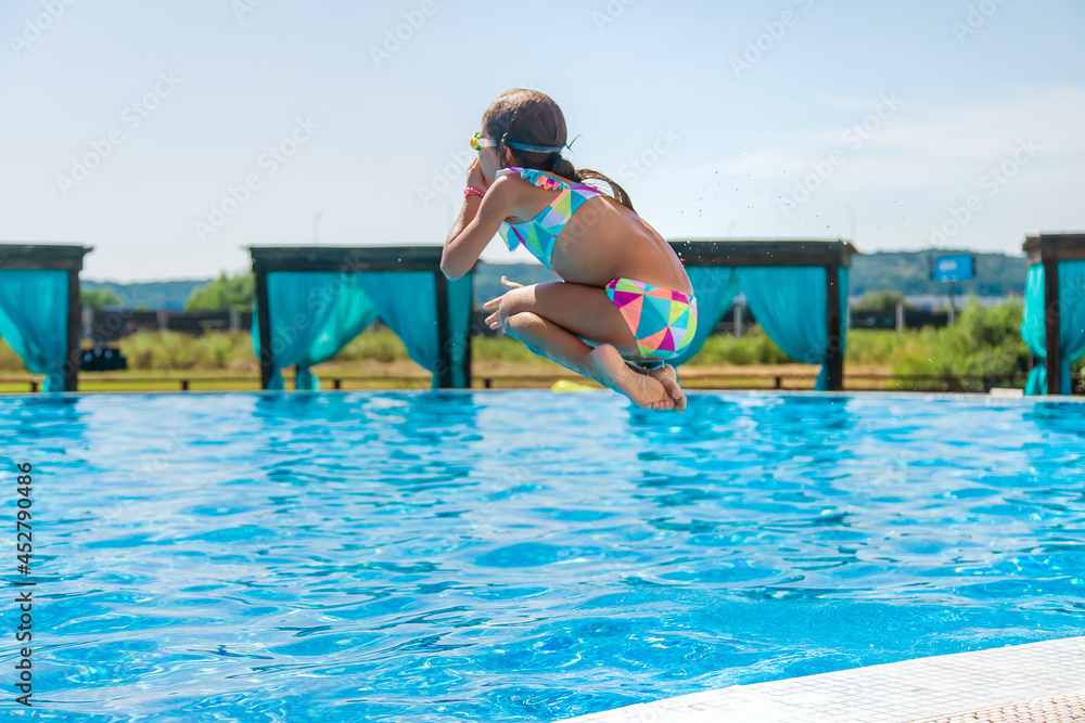 Fotografie The child jumps dives into the pool. Selective focus.