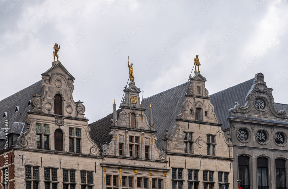 Antwerpen, Belgium - August 1, 2021: Grote Markt historic medieval houses. Row of 4 gables, the Luipaert, unknown, the Meersman, and the Beer against a gray sky. Golden statues and frescos.