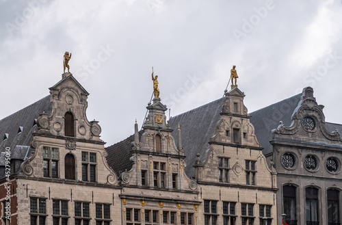 Antwerpen, Belgium - August 1, 2021: Grote Markt historic medieval houses. Row of 4 gables, the Luipaert, unknown, the Meersman, and the Beer against a gray sky. Golden statues and frescos. © Klodien