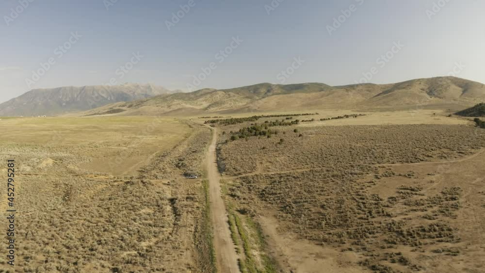 Aerial-Pulling back over desert dirt road through sagebrush flats on a hot dry day as extended drought in the western US continues Aerial-Pulling back over desert dirt road through sagebrush flats on a hot dry day as extended drought in the western US continues