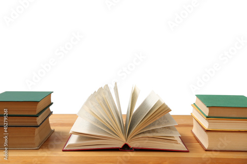 Many books on wooden table against white background. Library material