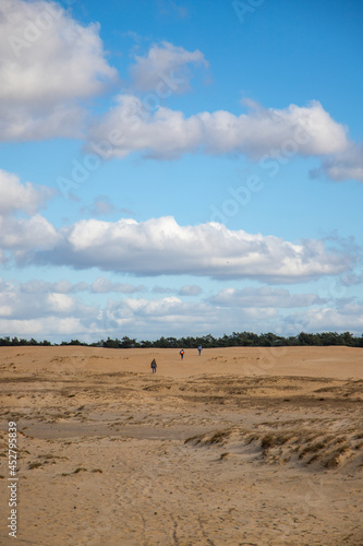 People walking through sand dunes