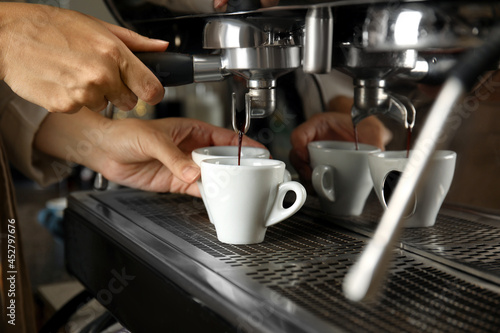 Barista making espresso using professional coffee machine  closeup