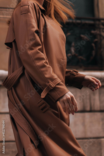 Cropped figure of a woman wearing stylish classic brown overcoat. Street casual autumn female fashion concept