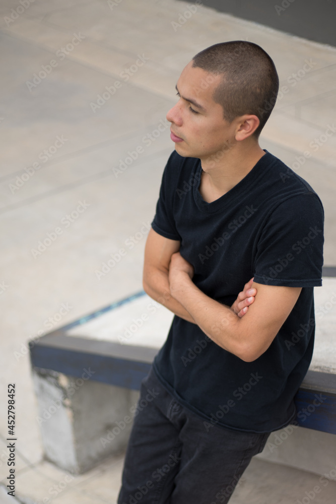 young latin man leaning against wall young latin man leaning against wall