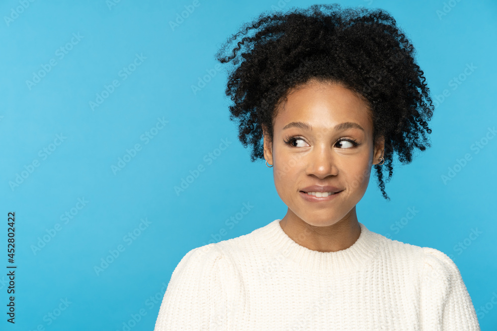 Curious intriguing black woman looking aside at copy space. Cunning young african american girl with ethnic hairstyle ponder having new idea with positive smile biting lip. Joyful afro female thinking Curious intriguing black woman looking aside at copy space. Cunning young african american girl with ethnic hairstyle ponder having new idea with positive smile biting lip. Joyful afro female thinking