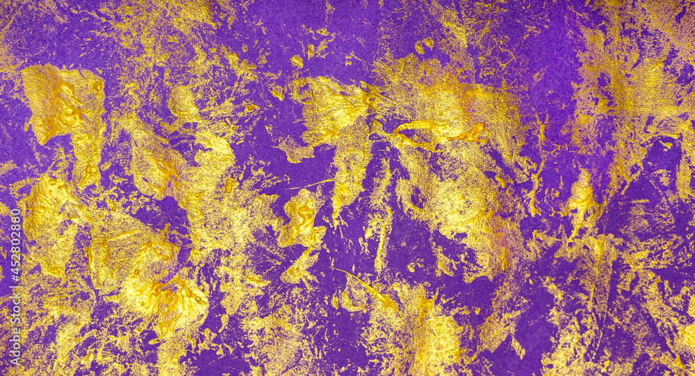 Brush strokes with gold paint on a purple paper background. Halloween. copy space. Festive, abstract background