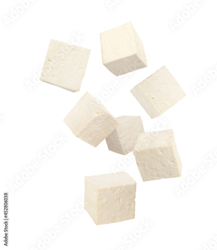 Quadro su tela Cubes of raw tofu falling on white background