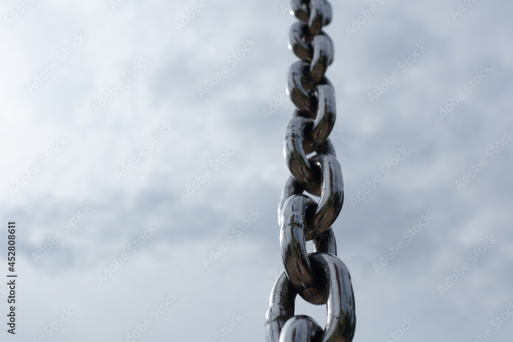 Steel chain with clouds on sky on background Steel chain with clouds on sky on background