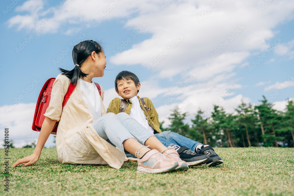 芝生に座る小学生
