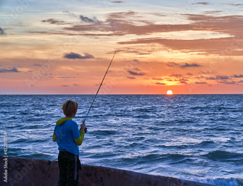 Young Boy Fishing at Sunset off a Pier in Mazatlán Mexico 