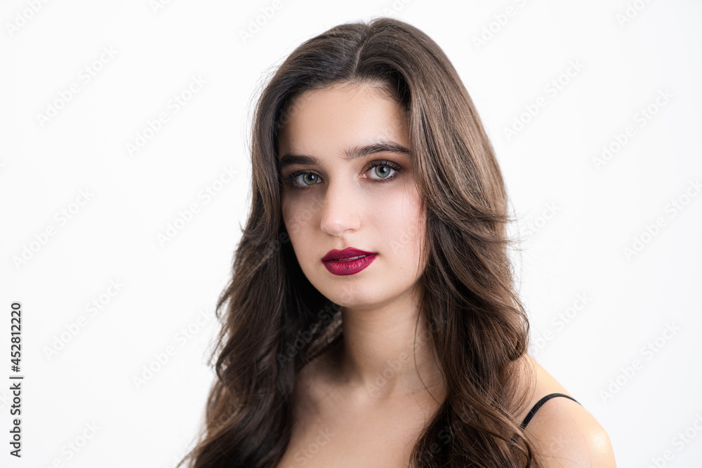 The girl with make-up and styling looks into the camera. Photo of a girl on a white background. The girl with make-up and styling looks into the camera. Photo of a girl on a white background.