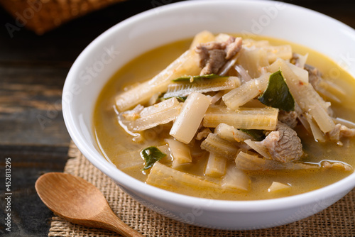 Local Thai food, Spicy banana stalk soup with pork in a bowl on wooden table