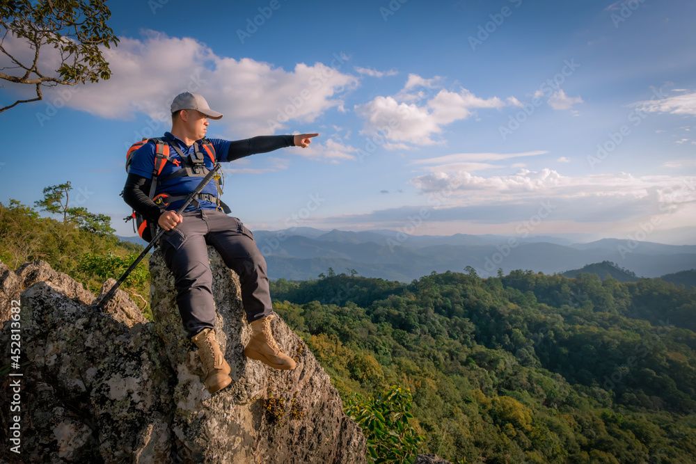 Travelers trekking backpacks on the rocky peaks, enjoying the magnificent views of the valleys on the front. Travelers trekking backpacks on the rocky peaks, enjoying the magnificent views of the valleys on the front.